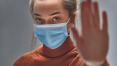 2176603 stockphotostopthevirusandepidemicdiseaseshealthywomaninbluemedicalprotectivemaskshowinggesture1633291840 ls