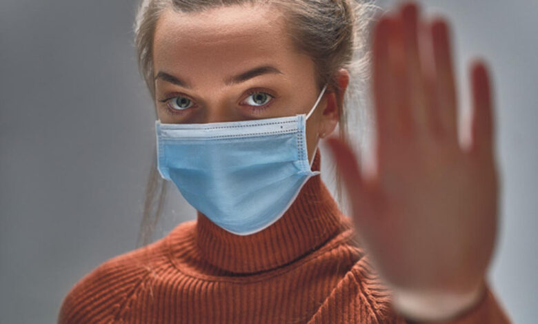 2176603 stockphotostopthevirusandepidemicdiseaseshealthywomaninbluemedicalprotectivemaskshowinggesture1633291840 ls